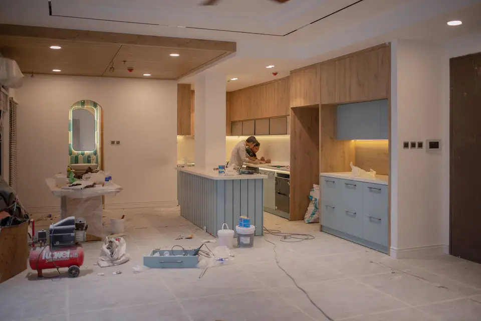 Cozinha moderna em reforma com um profissional, ferramentas e materiais de obra