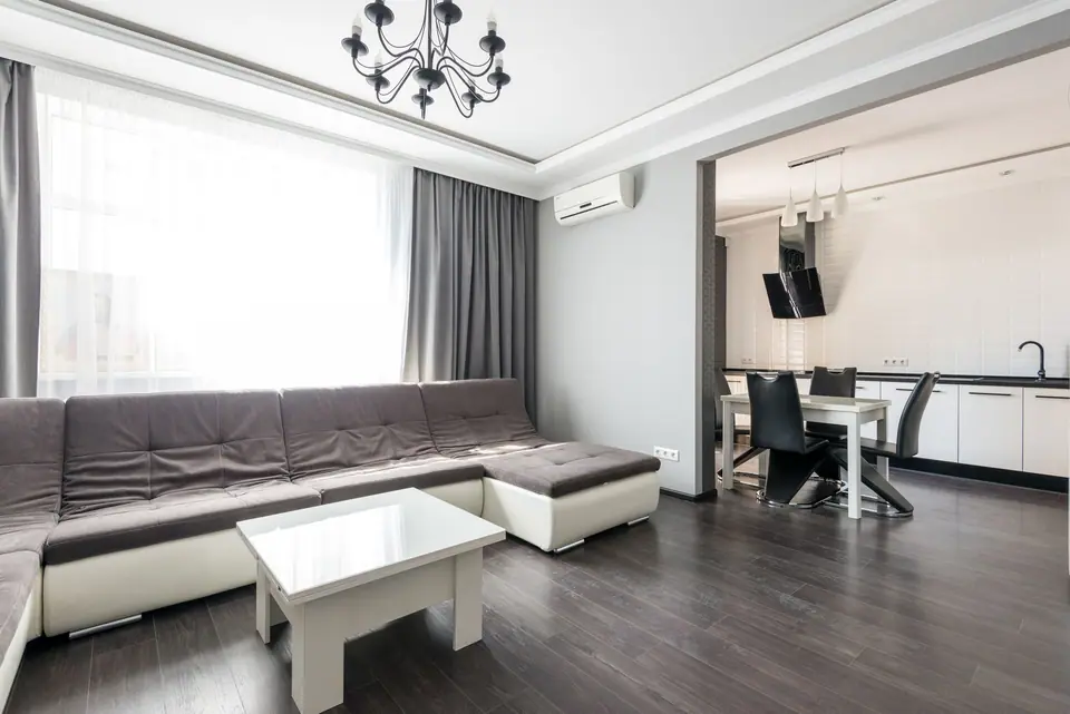 Apartamento iluminado com sala de estar e jantar integradas, piso de madeira e paredes brancas